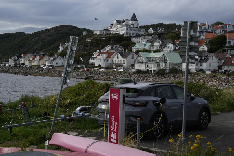 Une voiture électrique se recharge sur un parking dans un port de Mölle, au sud-ouest de la Suède.