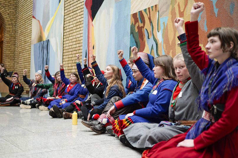 Des militants portant des costumes traditionnels sami manifestent dans la salle centrale du Storting, le parlement norvégien, à Oslo, le 11 octobre 2023.