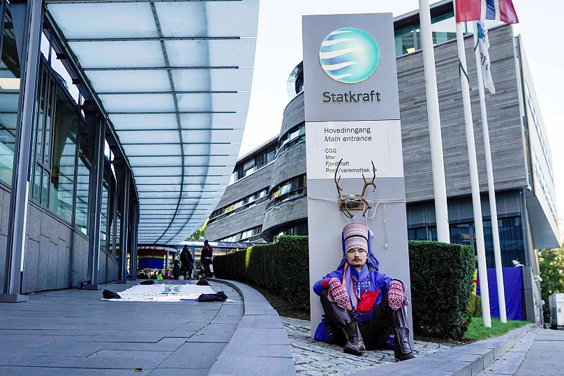 Le militant Mihkkal Hætta porte une tenue traditionnelle sami alors qu'il proteste devant l'entrée de Statkraft, une entreprise publique qui exploite 80 des éoliennes.