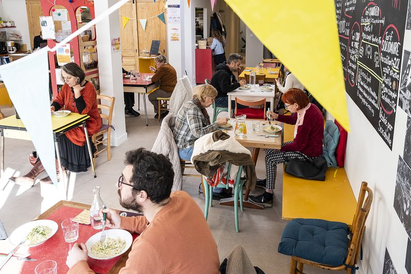 Des gens mangent à la cantine de la Maison Engagée et Solidaire de l'Alimentation (MESA) à Lyon le 8 octobre 2022