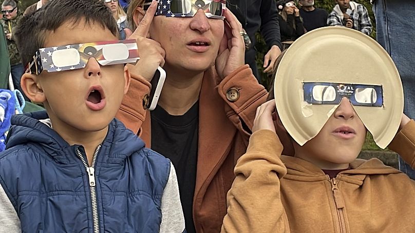 Samia Harboe, son fils Logan et le fils de son amie portent des lunettes d'éclipse pendant la totalité de l'éclipse solaire annulaire à Eugene, Oregon, États-Unis, le samedi 14 octobre 2023.