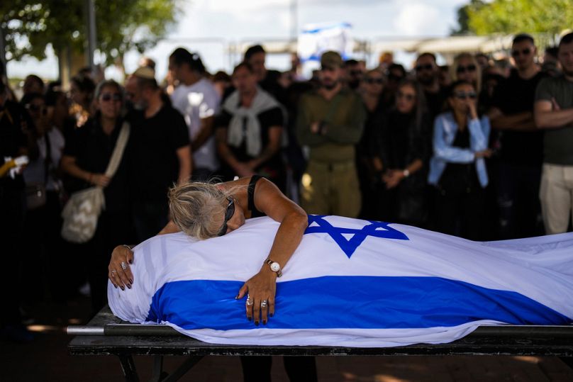 Une mère pleure sur le corps de son fils recouvert du drapeau israélien au cimetière Pardes Haim à Kfar Saba, près de Tel Aviv, octobre 2023