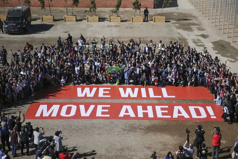 Les participants à la conférence sur le climat COP22 posent en soutien aux négociations sur le climat et à l'accord de Paris, le dernier jour de la conférence, à Marrakech, novembre 2016.