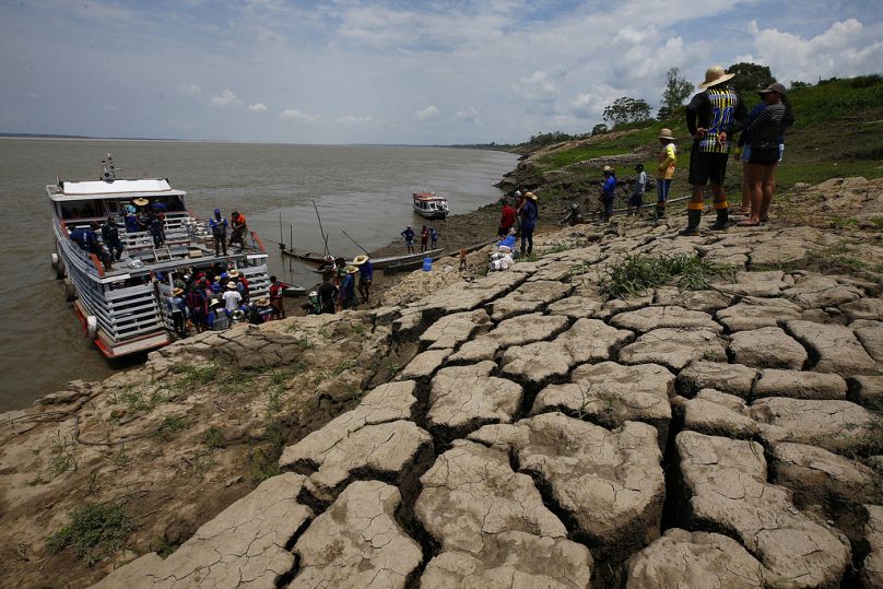 Les habitants d'une communauté riveraine transportent de la nourriture et des récipients d'eau potable après avoir reçu une aide en raison de la sécheresse persistante à Careiro da Varzea, dans l'État d'Amazonas, le 24 octobre.