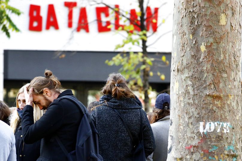 Des gens se tiennent devant la salle de concert du Bataclan lors d'une cérémonie marquant le deuxième anniversaire des attentats de Paris, le lundi 13 novembre 2017.