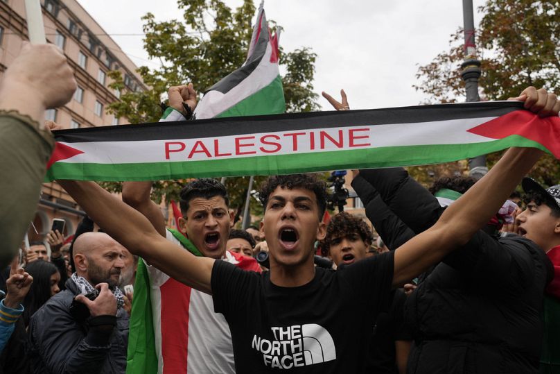 Des manifestants brandissent des drapeaux et crient des slogans se rassemblent pour un rassemblement pro-palestinien à Rome, le samedi 21 octobre 2023.