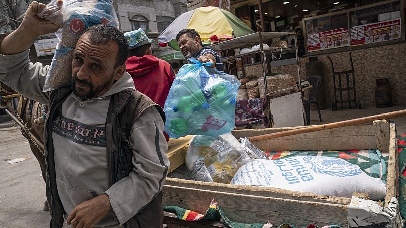 Des Palestiniens récupèrent de la nourriture fournie par l'agence des Nations Unies pour les réfugiés palestiniens (UNRWA) dans la ville de Gaza, mai 2021.