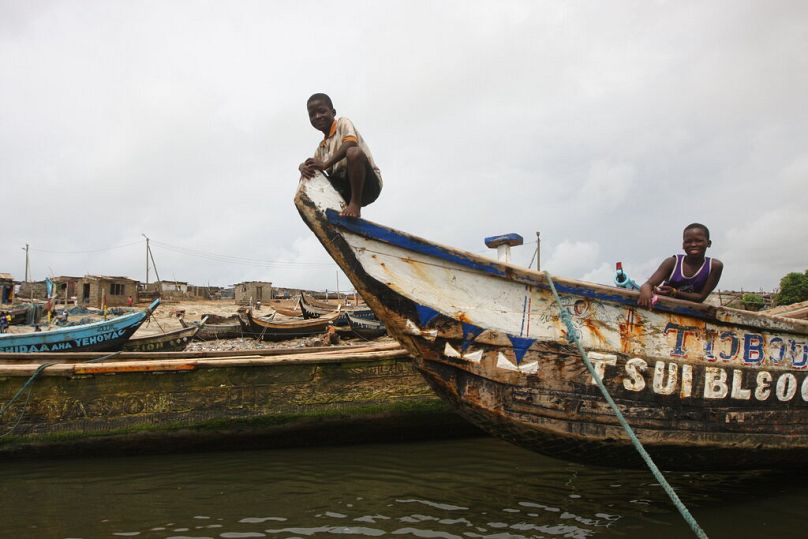 Deux garçons jouent sur un bateau de pêche à l'extérieur d'Accra, mai 2012.