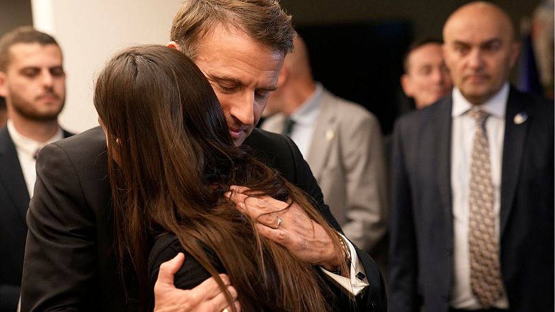Macron embrasse une femme alors qu'il rencontre des ressortissants israélo-français qui ont perdu des proches, ainsi que des familles d'otages, à l'aéroport Ben Gourion, mardi à Tel Aviv.
