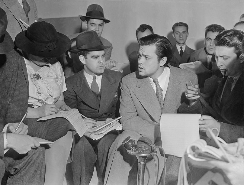 Photo d'Orson Welles rencontrant des journalistes pour tenter d'expliquer que personne lié à l'émission radiophonique de la Guerre des Mondes n'avait la moindre idée que l'émission provoquerait la panique.