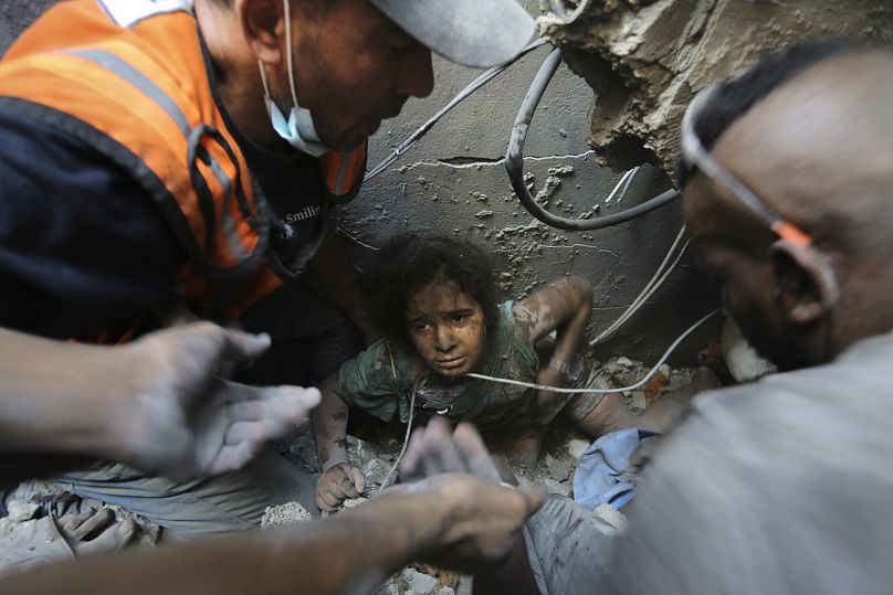 Des Palestiniens tentent de sortir une jeune fille des décombres d'un bâtiment détruit mercredi par les frappes aériennes israéliennes dans le camp de réfugiés de Jabaliya, au nord de la bande de Gaza.