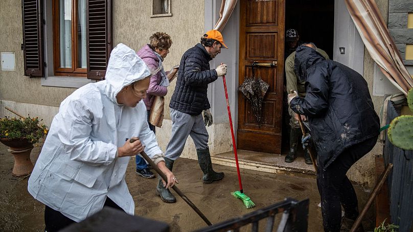 Des gens nettoient une maison inondée à Montemurlo, près de Prato, après de fortes pluies la nuit dernière, le 3 novembre 2023.