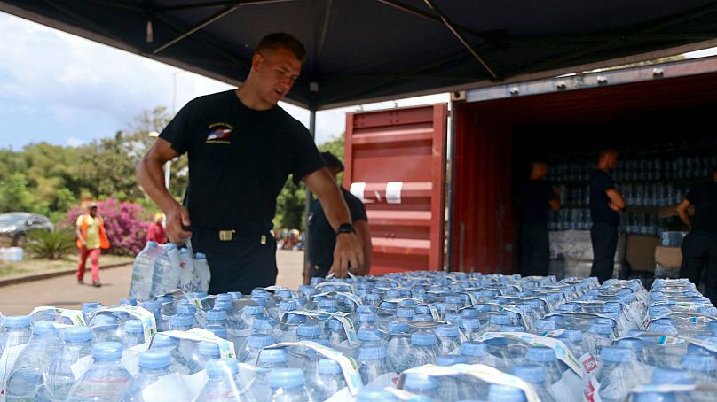 Un agent de sécurité récupère des bouteilles d'eau pour les habitants de Tsoundzou, sur le territoire français de Mayotte, dans l'océan Indien, le 21 octobre 2023.