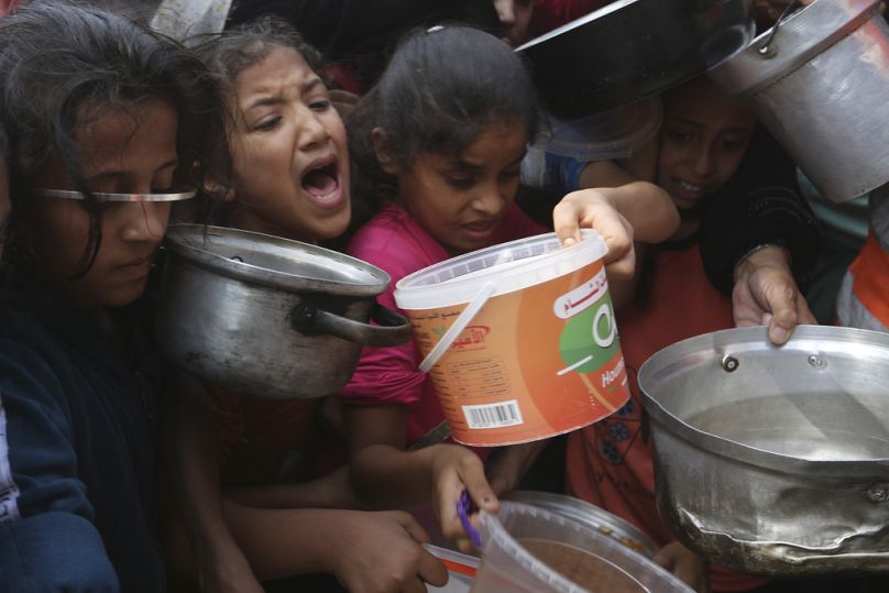 Des Palestiniens font la queue pour obtenir de la nourriture lors du bombardement israélien en cours sur la bande de Gaza à Rafah, le lundi 13 novembre 2023.