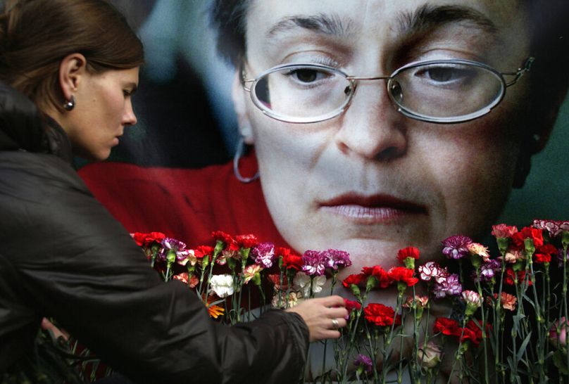 Sur cette photo d'archive du 7 octobre 2009, une femme dépose des fleurs devant un portrait de la journaliste russe assassinée Anna Politkovskaïa, à Moscou.