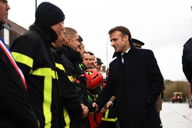 Le président Emmanuel Macron serre la main des membres des équipes de secours à Blendecques, dans le nord de la France, mardi