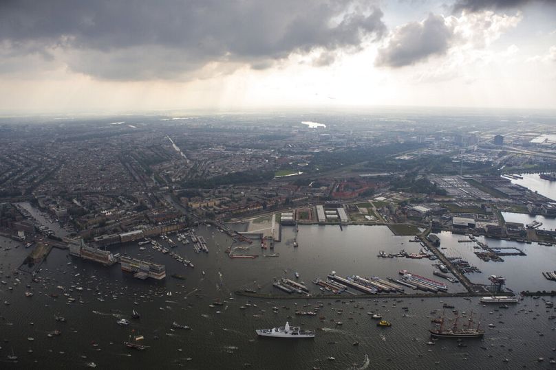 De grands voiliers escortés par de petits bateaux arrivent à Amsterdam, août 2015