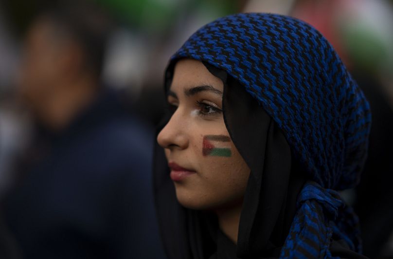 Une femme affiche le drapeau palestinien dessiné sur son visage lors d'une marche pro-palestinienne dans le centre-ville de Hamilton, en octobre 2023.