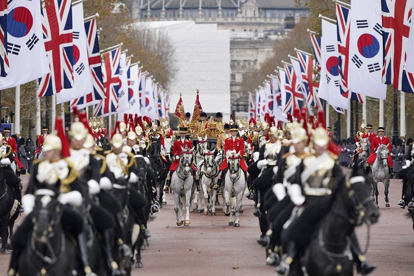 Des drapeaux britanniques et sud-coréens bordent le centre commercial lors d'une procession militaire pour la cérémonie de bienvenue du président sud-coréen