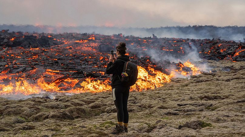 Une personne marche près de la lave émergeant d’une fissure du volcan Fagradalsfjall, près de la montagne Litli-Hrútur, le 10 juillet 2023.