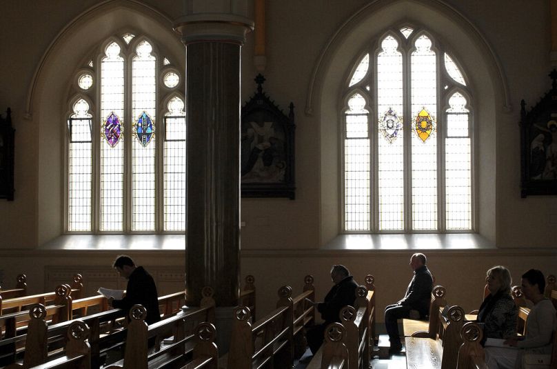 Les catholiques romains écoutent l'évêque Noel Treanor pendant la messe à la cathédrale catholique romaine Saint-Pierre, à l'ouest de Belfast, en Irlande du Nord.