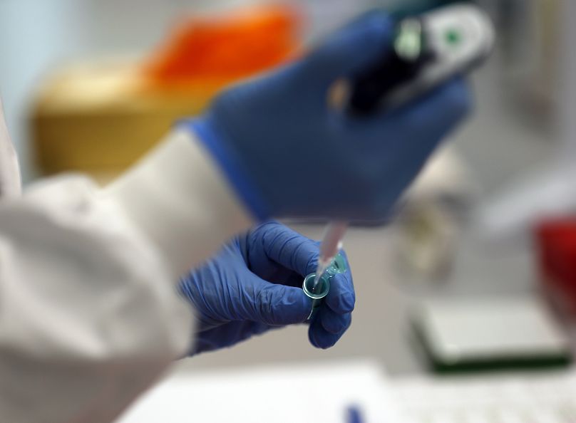 Un assistant de laboratoire utilise une pipette pour préparer l’ARN du coronavirus pour le séquençage au Wellcome Sanger Institute de Cambridge, 2021.