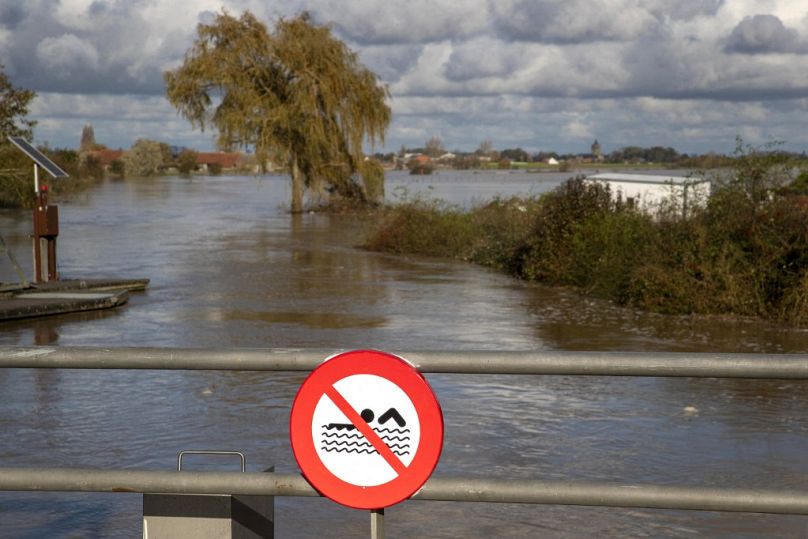 Cette vue générale depuis un pont avec un panneau « baignade interdite » montre des champs inondés par les eaux de crue à Poperinge, en Flandre occidentale, le 11 novembre 2023.