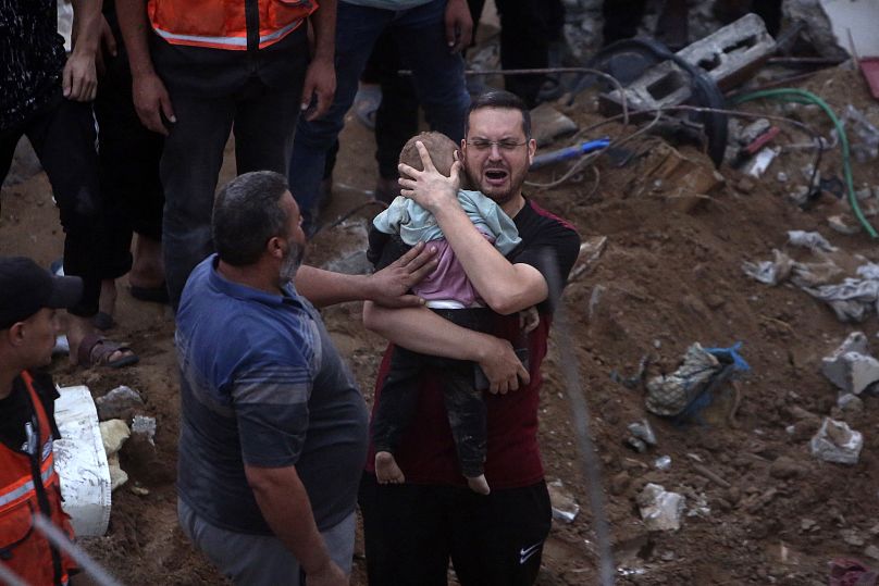 Un Palestinien pleure en tenant dans ses bras un enfant mort retrouvé sous les décombres d'un bâtiment détruit suite aux frappes aériennes israéliennes dans le camp de réfugiés de Nusseirat mardi.