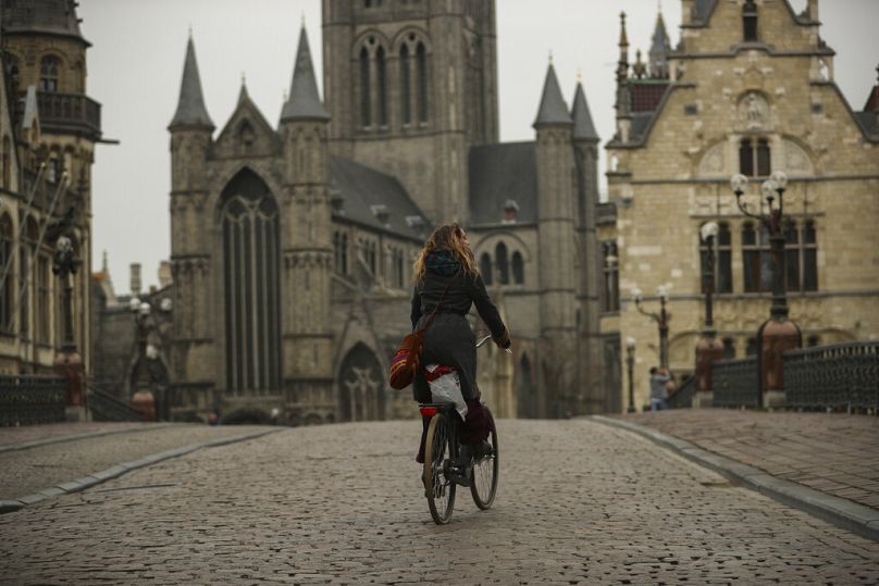 Une femme fait du vélo dans le centre-ville de Gand, mars 2020