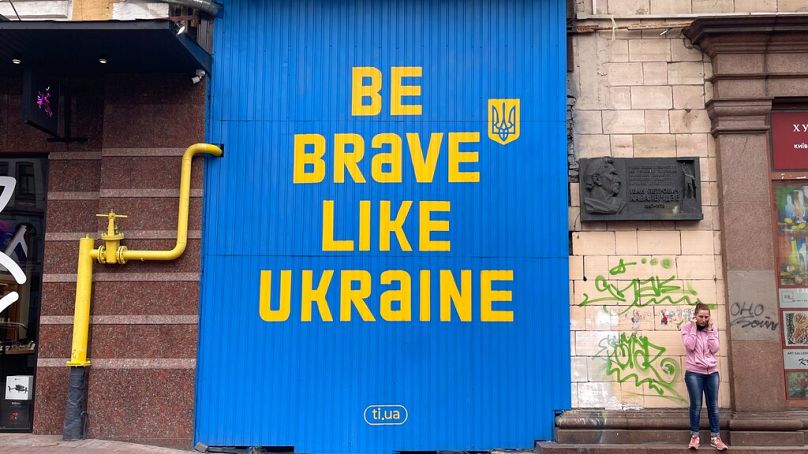 Une femme parle sur un téléphone portable alors qu’elle se tient dans la rue à Kiev, en Ukraine, le samedi 17 septembre 2022.