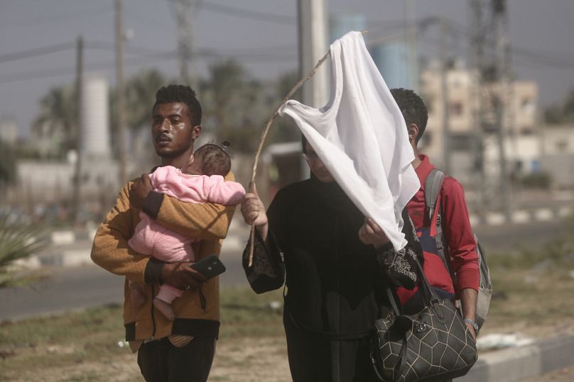 Une femme brandit un T-shirt blanc essayant d'éviter d'être abattue, alors que les Palestiniens fuient la ville de Gaza vers le sud de la bande de Gaza, dans la rue Salah al-Din à Bureij, mardi 11/07/23.