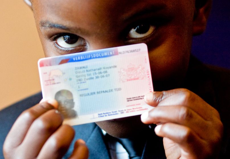 Un homme montre son nouveau permis de séjour à Den Bosch, juillet 2007