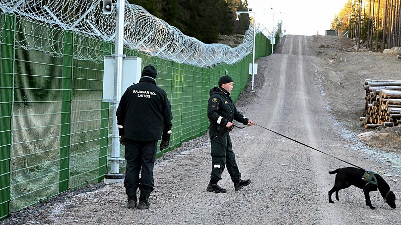 DOSSIER : Des membres de l'agence finlandaise des gardes-frontières (RAJA) avec une patrouille de chiens le long d'une section de la clôture frontalière pilote à Imatra, octobre 2023