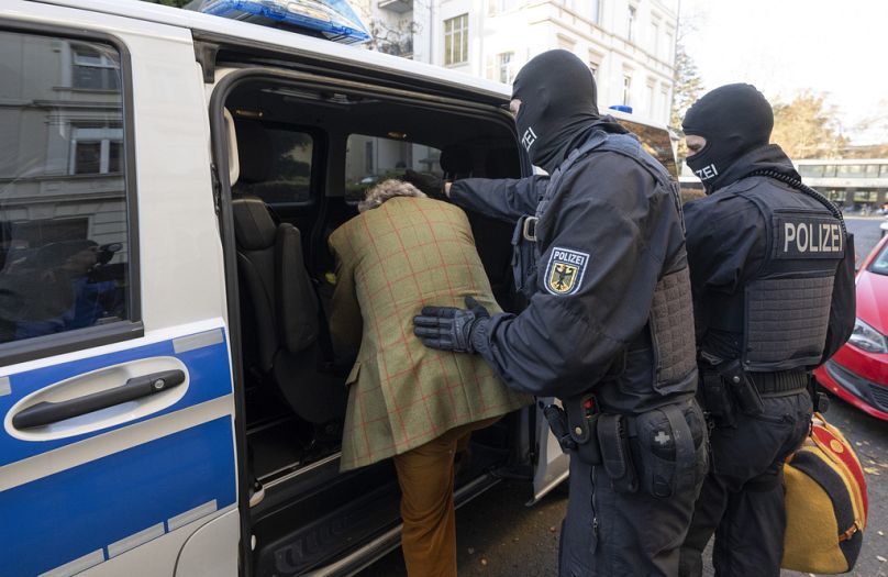 Des policiers embarquent Heinrich XIII Prince Reuss dans un véhicule de police lors d'un raid contre le mouvement Reichsbürger en décembre 2022.