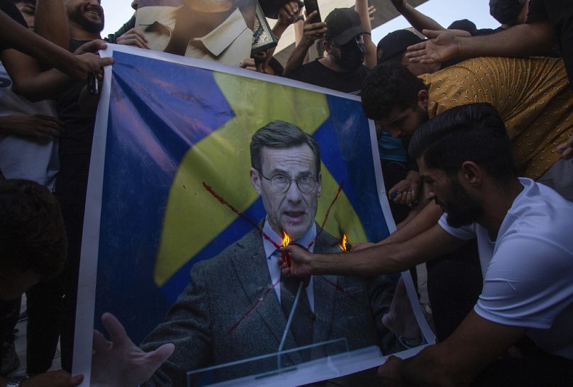 Les Irakiens brûlent la photo du Premier ministre suédois Ulf Kristersson lors d'une manifestation sur la place Tahrir.