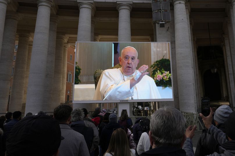 Un écran géant retransmet le pape François délivrant sa bénédiction lors de la prière de l'Angélus de midi depuis la chapelle de l'hôtel situé sur le terrain du Vatican où il réside, dimanche 11 novembre.