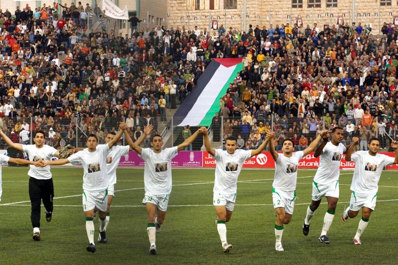 DOSSIER – Dans cette photo d'archive du 26 octobre 2008, des joueurs de l'équipe palestinienne de football sont vus sur le terrain avant un match contre la Jordanie dans un stade de la ville d'Aram en Cisjordanie.