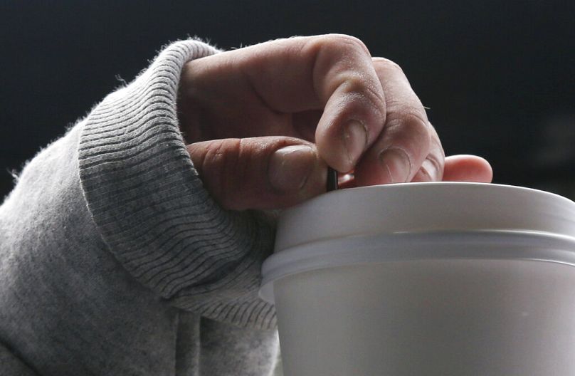 Une femme serre son agitateur à café, juillet 2010