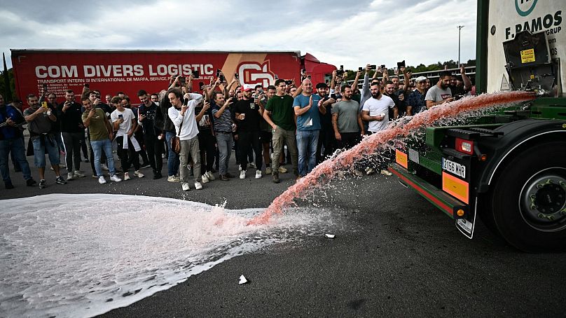 Des vignerons renversent du vin d'un camion lors d'une manifestation contre les importations de vin espagnol, le 19 octobre 2023.