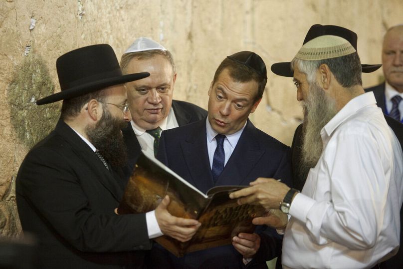 L'ancien président russe Dmitri Medvedev reçoit un livre lors de sa visite au Mur Occidental, le lieu le plus saint où les Juifs peuvent prier dans la vieille ville de Jérusalem, le 10 novembre 2016.