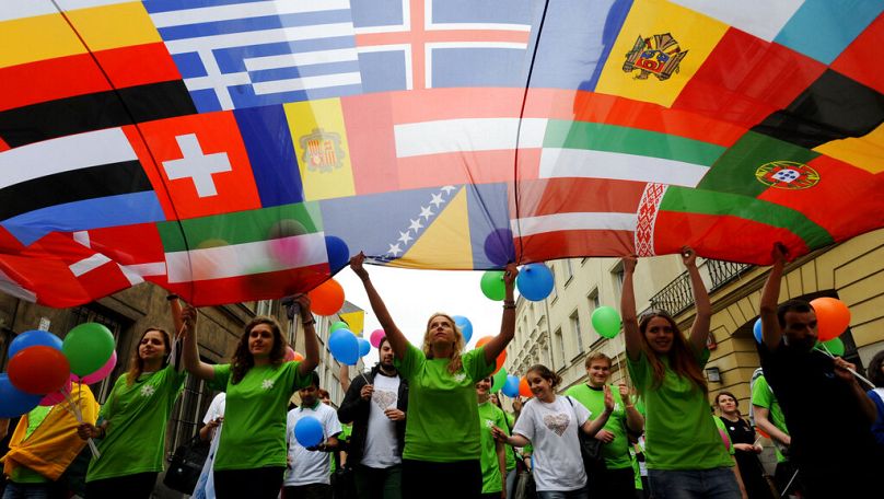 Des jeunes portent une banderole avec des drapeaux de pays européens lors d'un défilé annuel en l'honneur de Robert Schumann à Varsovie, en mai 2013.