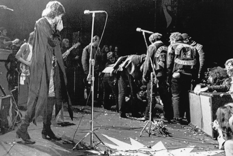 Mick Jagger arrête de se produire au Altamont Rock Festival à Livermore, en Californie, le 8 décembre 1969, tandis que les Hells Angels traversent la scène pendant une mêlée pour aider d'autres motocyclistes.