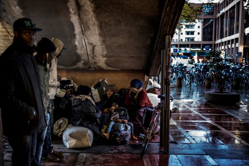 Des gens s'apprêtent à dormir sous des escaliers, le 13 novembre 2017 dans une rue de Lyon, trois jours après avoir été expulsés d'un camp de fortune.