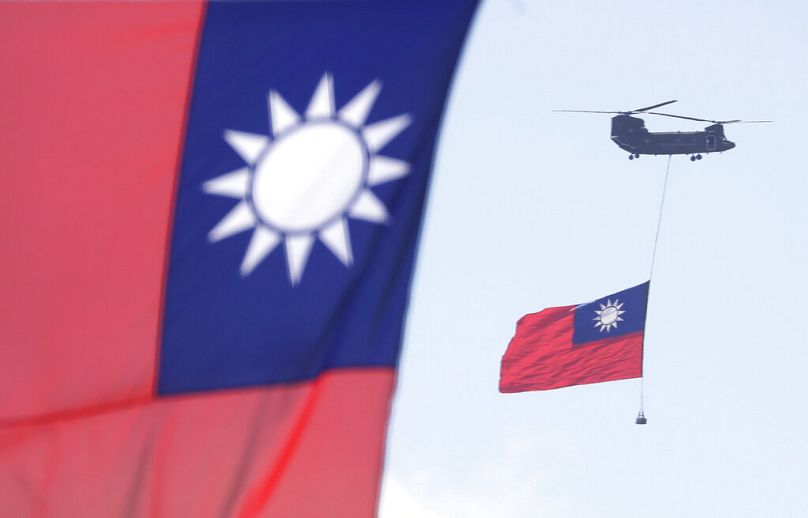 Des hélicoptères survolent le bureau du président avec le drapeau national de Taiwan lors des célébrations de la fête nationale devant le bâtiment présidentiel à Taipei, octobre 2021