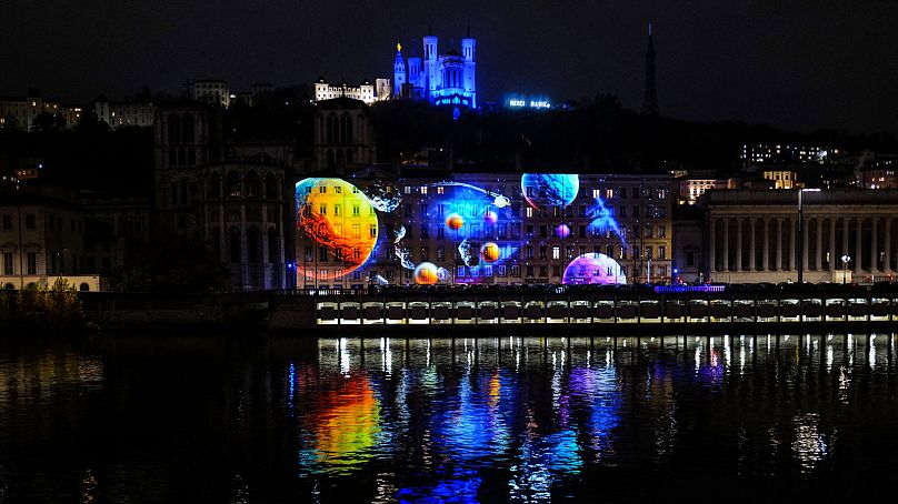 La colline de Fourvière est vue avec la basilique lors de la Fête des Lumières de l'année dernière.  La statue dorée de la Vierge Marie se trouve au sommet de la basilique.