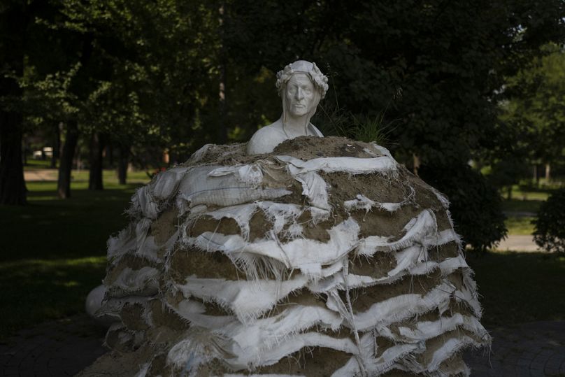 Des sacs de sable altérés sont empilés autour du monument à Dante Alighieri pour protéger la statue d'un éventuel bombardement russe à Kiev, juillet 2023.