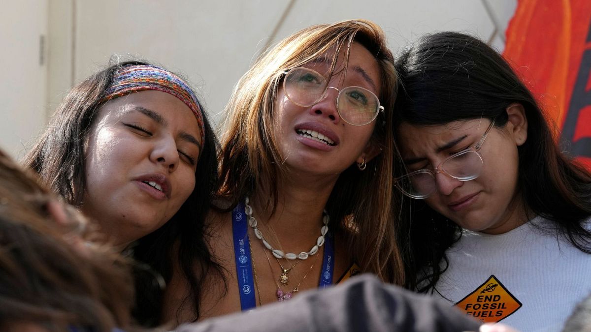 Mitzi Jonelle Tan, of the Philippines, embraces Adriana Calderon Hernandez, right, and other activists at the end of a protest against fossil fuels at COP28 this morning.