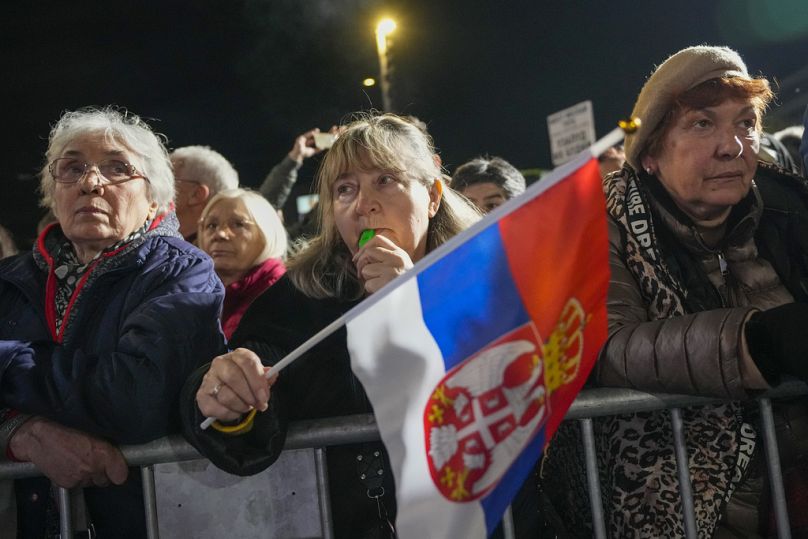 Une femme brandit un drapeau serbe lors d’un dernier rassemblement préélectoral de l’opposition 