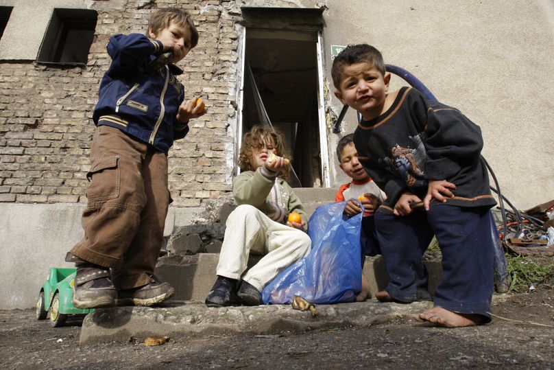 Des enfants roms jouent en mangeant des fruits devant leur logement temporaire dans le centre-ville de Sarajevo, en Bosnie, le vendredi 12 novembre 2010.