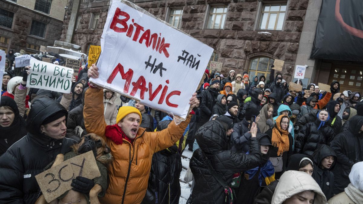 An activist holds a sign reading